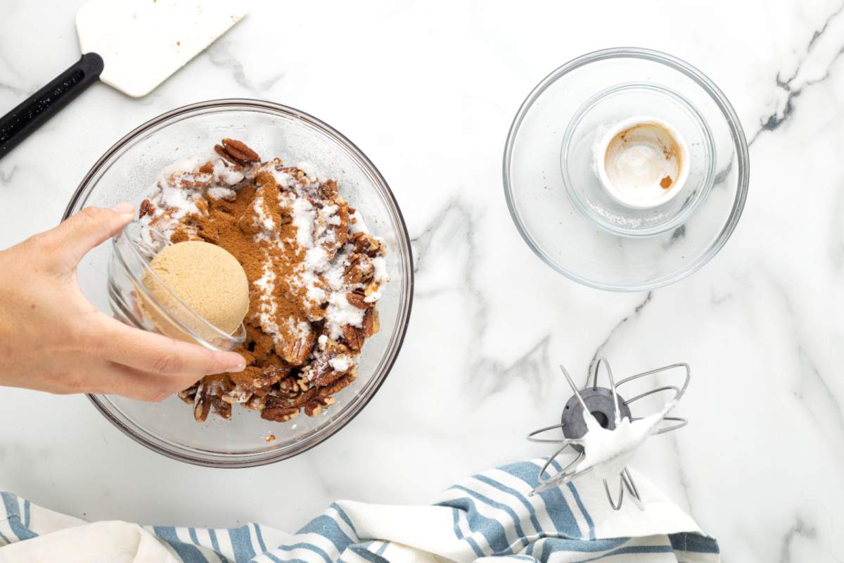 adding nuts and sugars in the bowl with egg whites