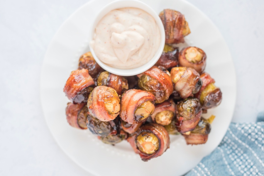 Bacon Wrapped Brussels Sprouts on a Plate with Sauce