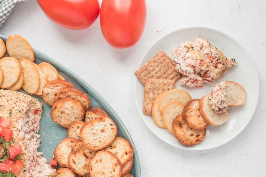 a Bruschetta Cheese Ball on a plate with biscuits