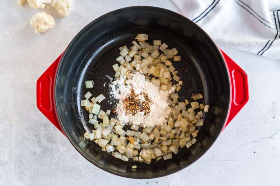 adding butter, flour, spices and fresh thyme to the pot with onions