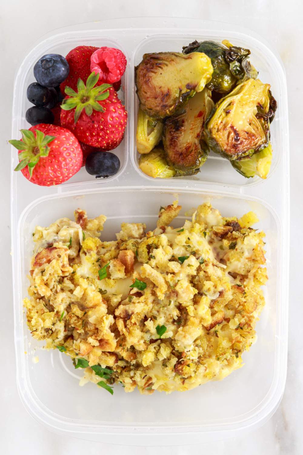 Crockpot Chicken Cordon Bleu and Stuffing packed in a lunch box with fruits and vegetables