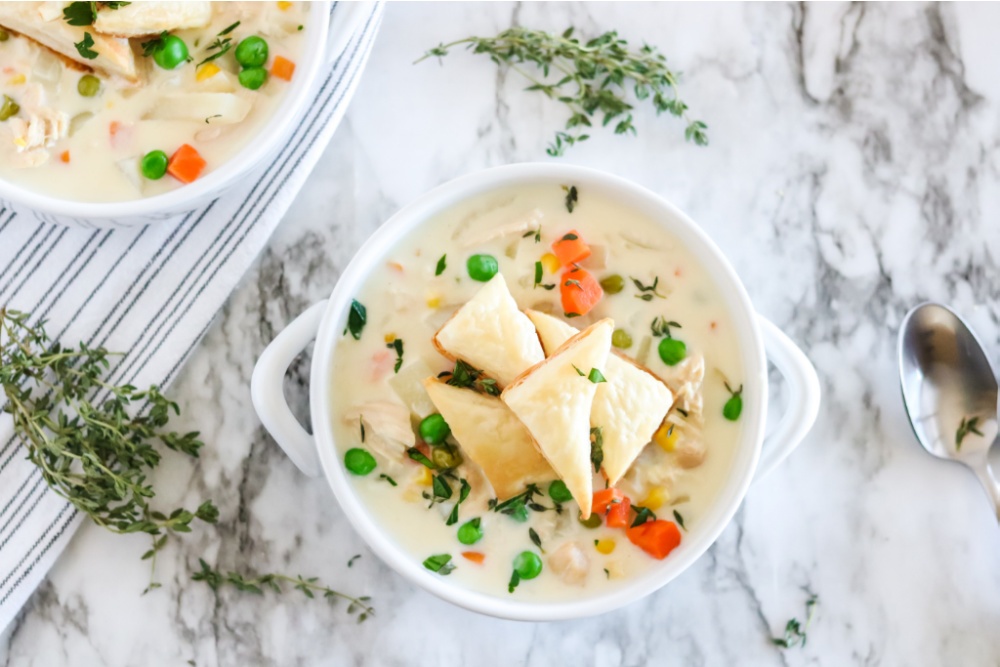 Crockpot Chicken Pot Pie soup in a white bowl, with triangles of puff pastry on top