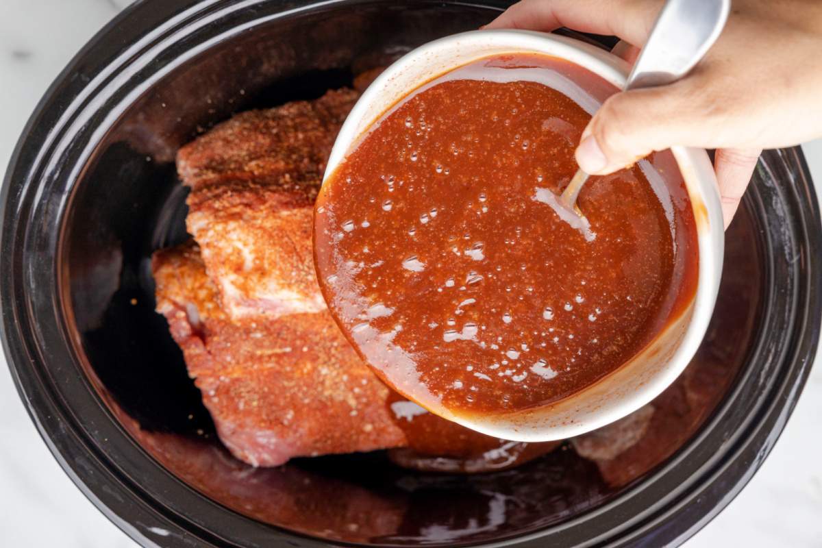 the sauce is poured over the ribs