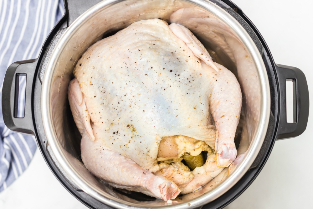Instant Pot Dill Pickle Chicken: whole chicken stuffed with dills inside a pressure cooker