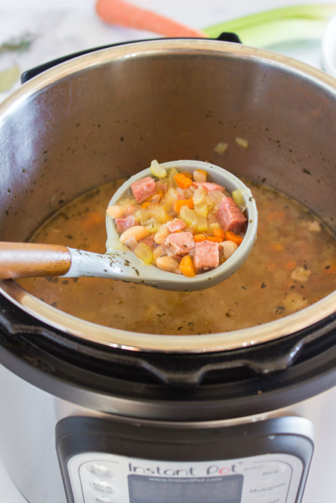 Instant Pot Ham and Bean Soup - soup in an instant pot, with a spoon scooping the soup