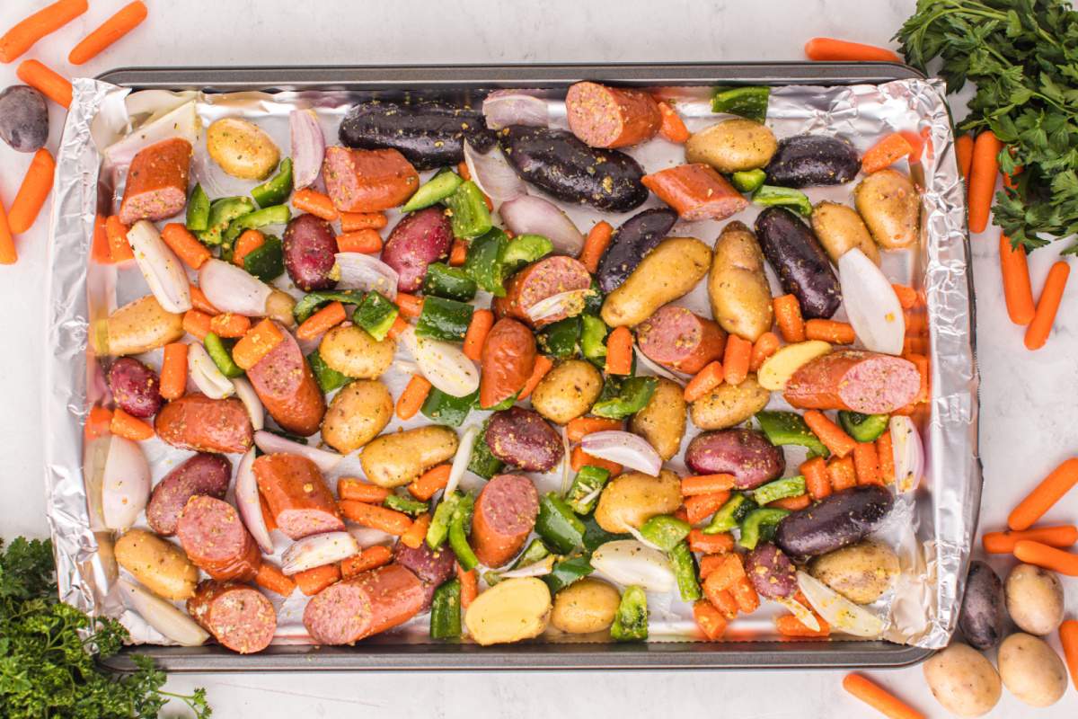 vegetables and sausages on a baking sheet