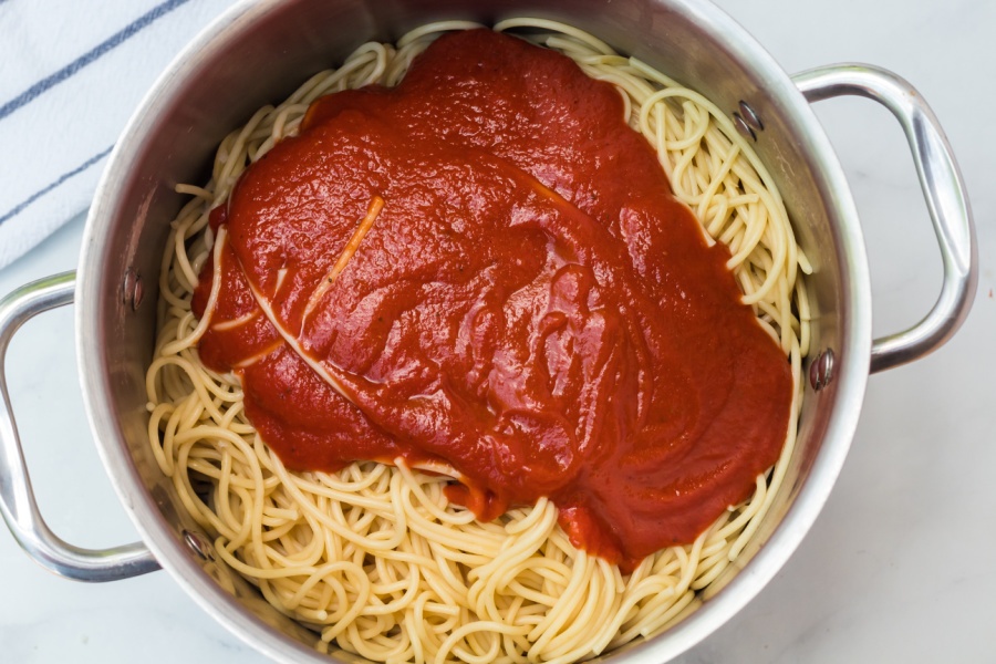 sauce on top of pasta in a pot