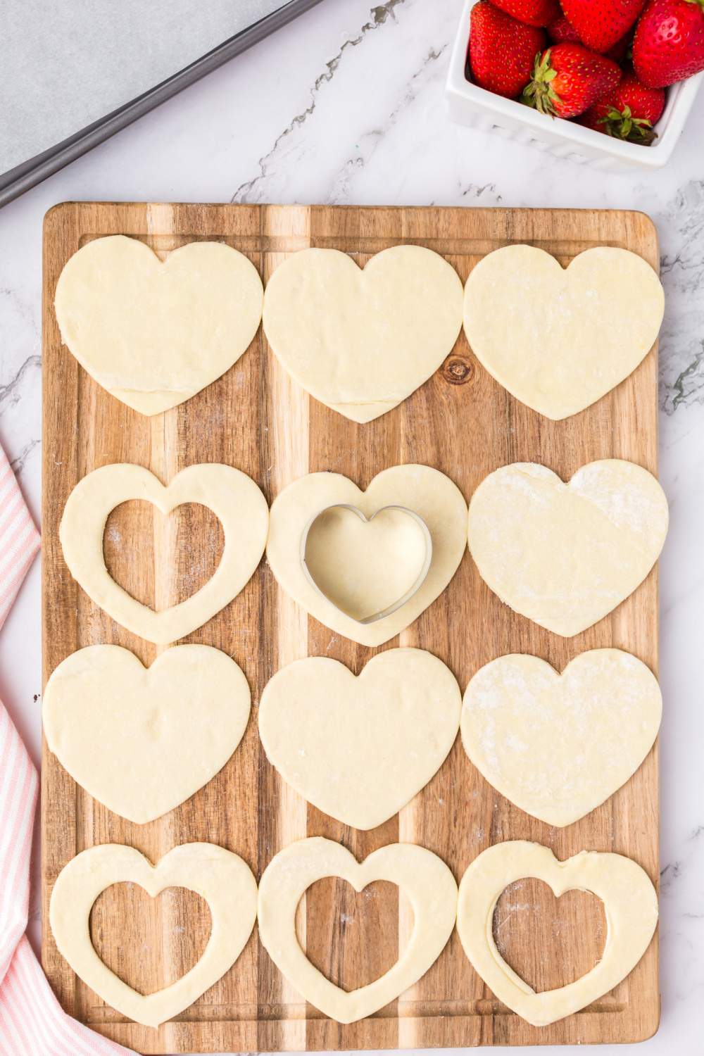cutting smaller hearts from the center of puff pastry hearts