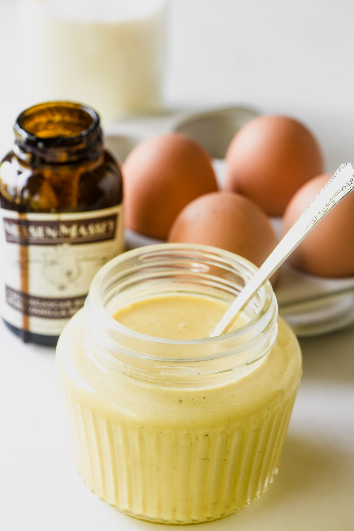 Creme Anglaise in a small jar with spoon.