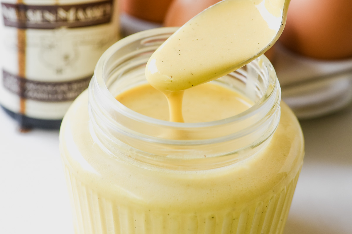 Spoonful of crème anglaise from a jar. 