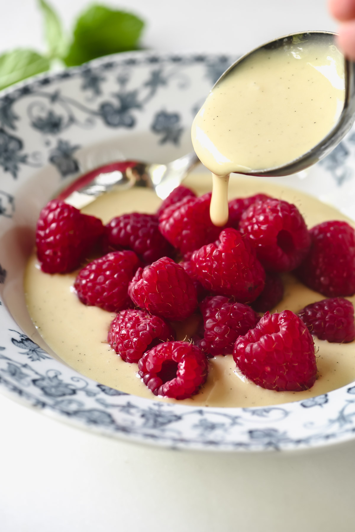 Spoon Creme Anglaise over fresh berries.