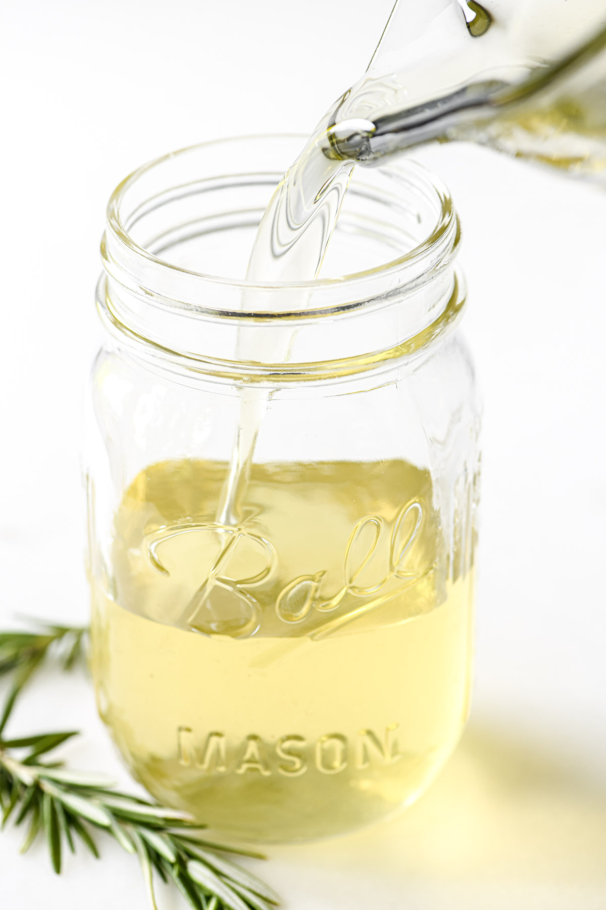 Pour rosemary simple syrup into a mason jar.