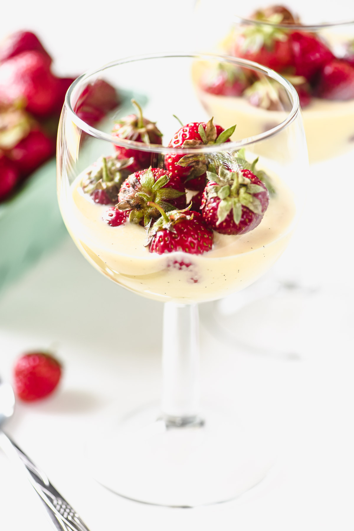 Tiny strawberries in Creme Anglaise in a stemless wine glass.