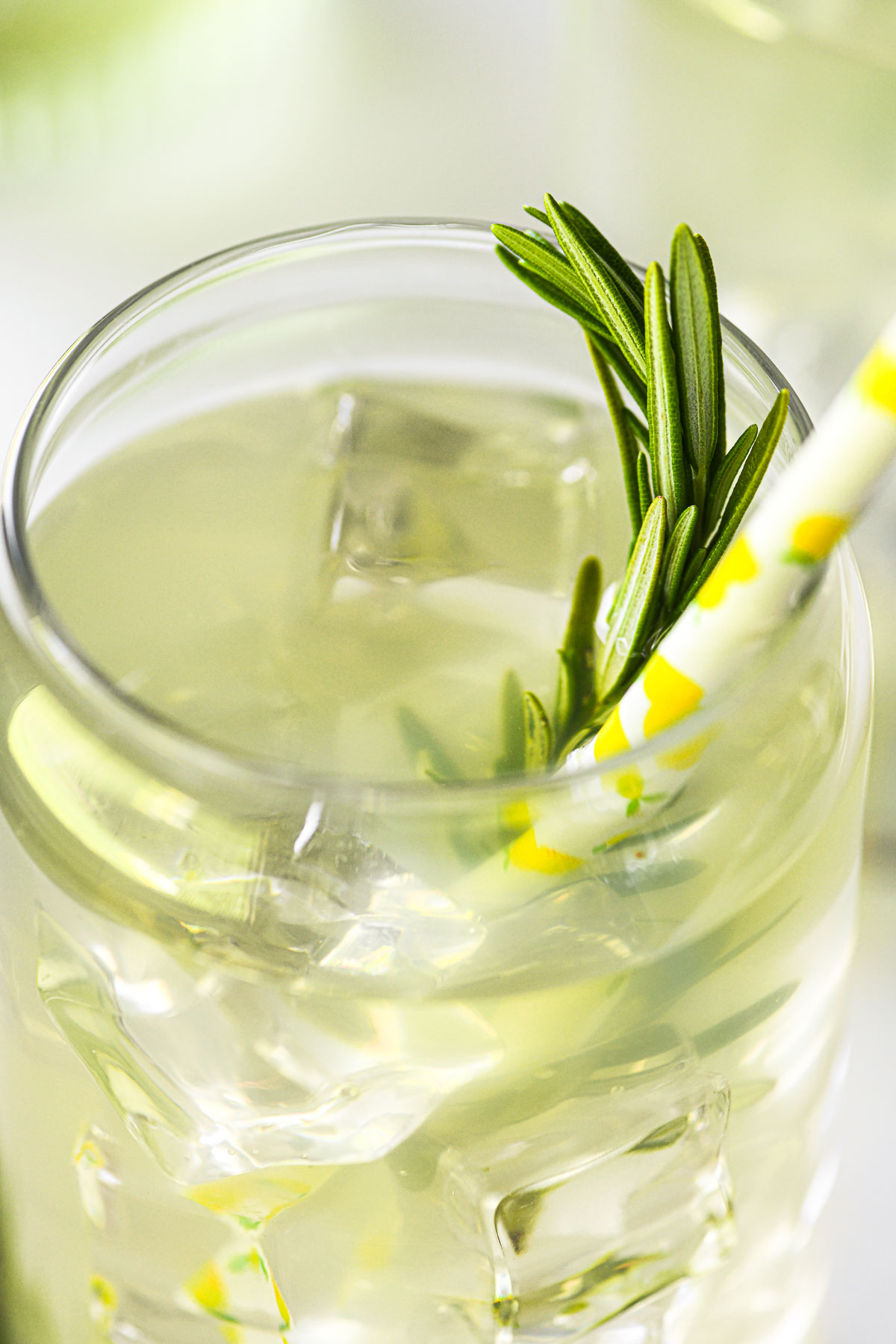 Rosemary lemonade with straw and rosemary sprig