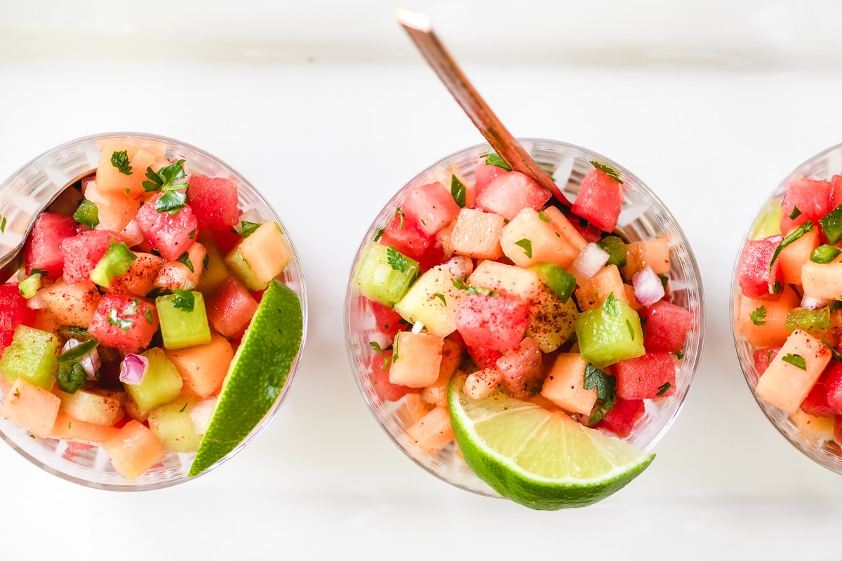 Small bowls of melon salad, with limes.