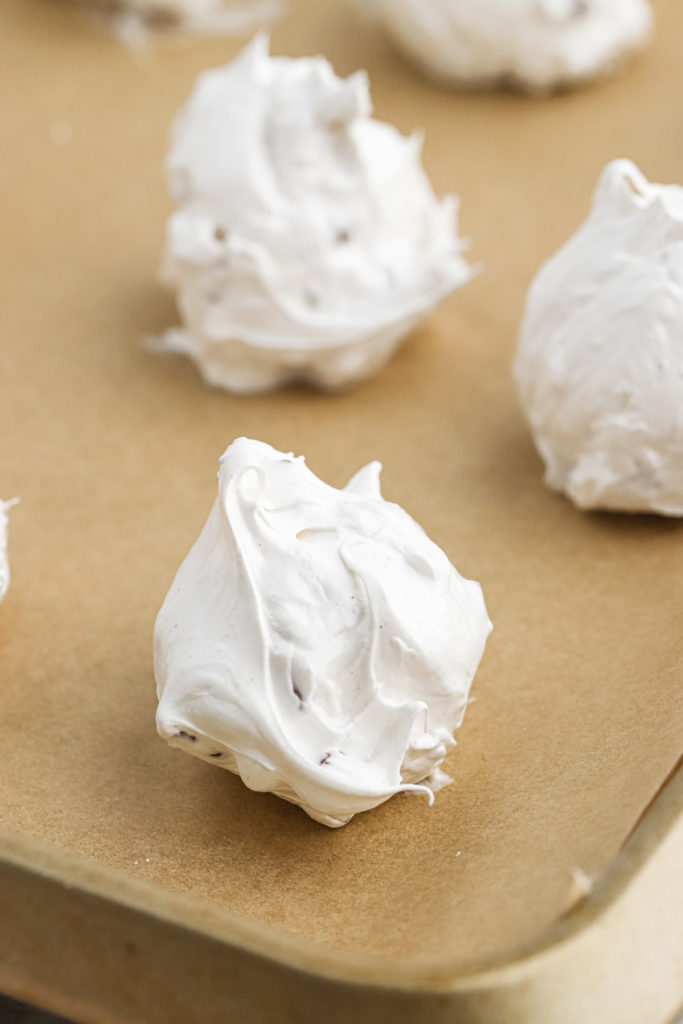 Tablespoons of meringue candy on parchment paper