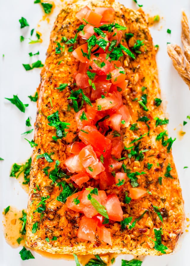 on top of a lemon garlic halibut fillet topped with diced tomatoes and parsley