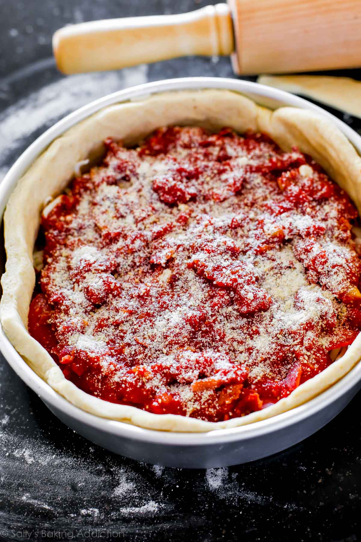 deep dish pizza in a baking pan before baking