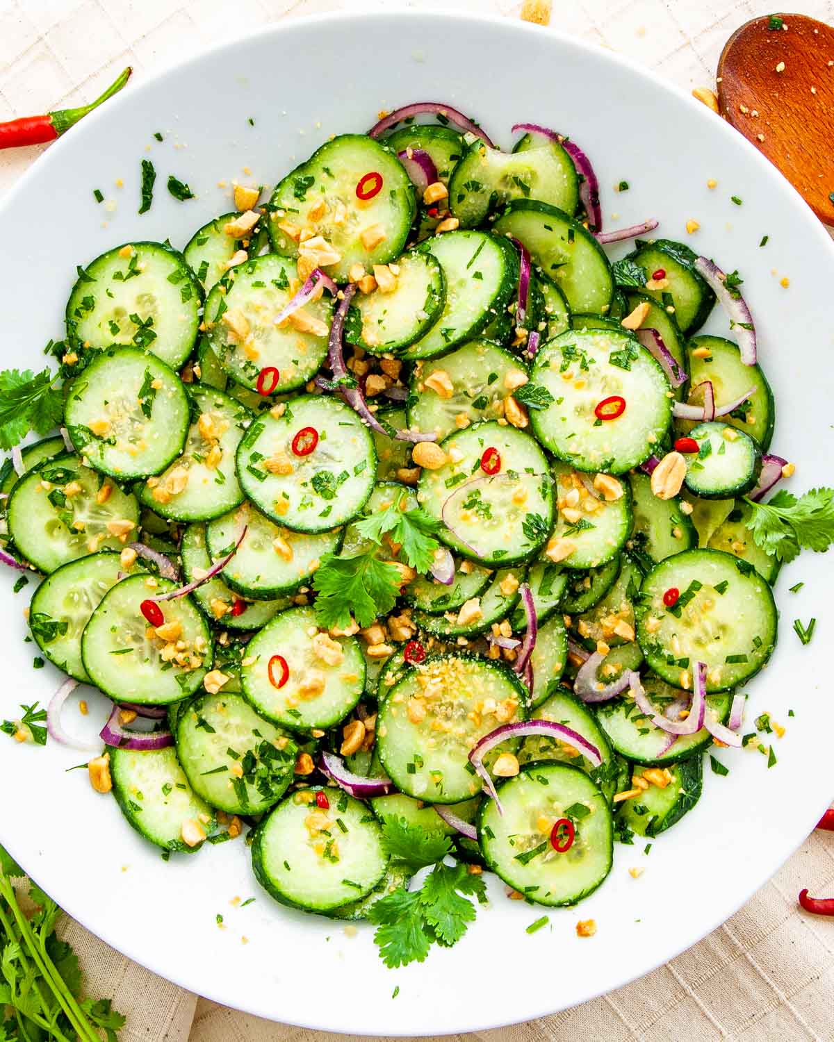 Overhead shot of freshly made Thai cucumber salad on a white plate.