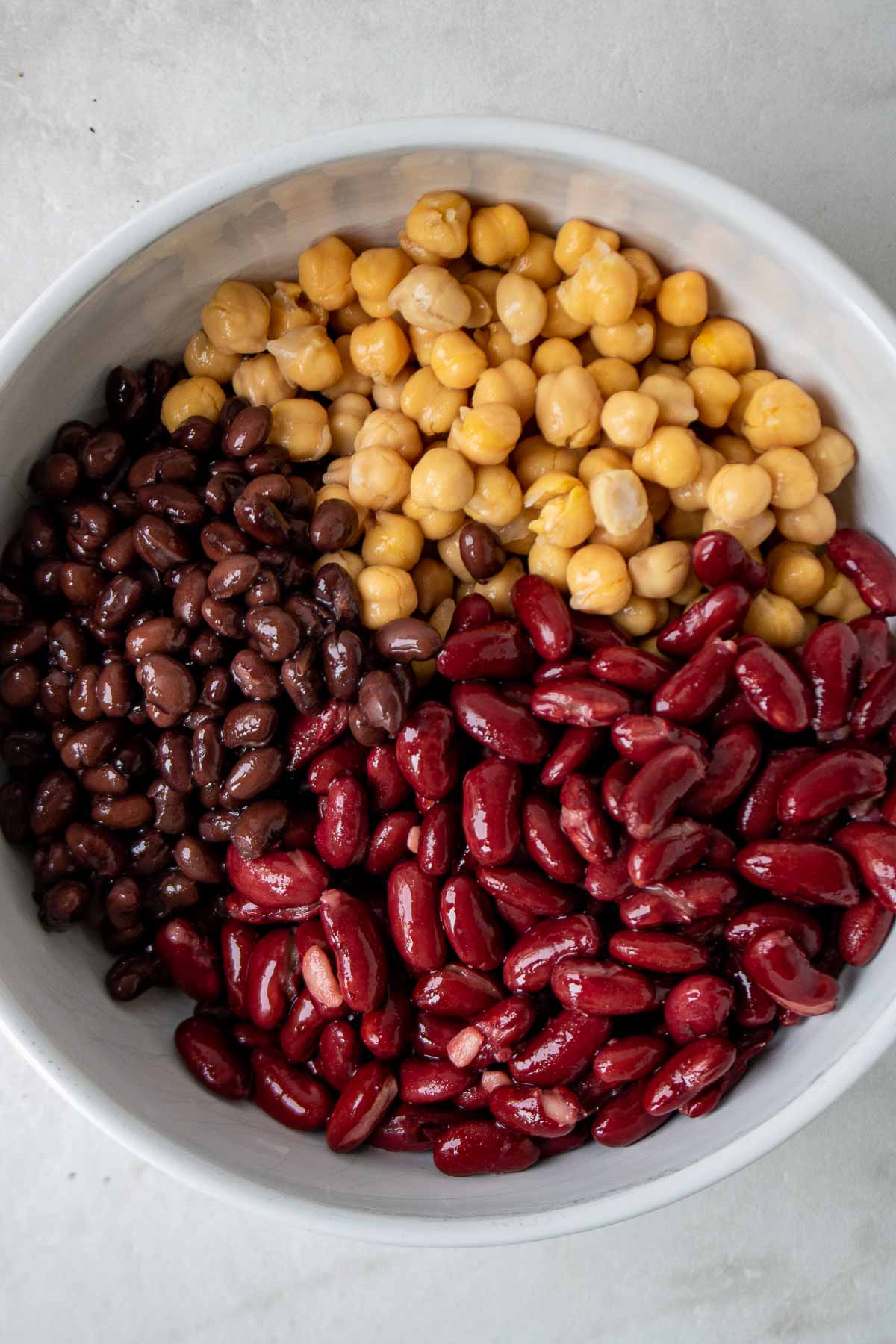 Garbanzo beans (chickpeas), black beans, and black beans in a white bowl.