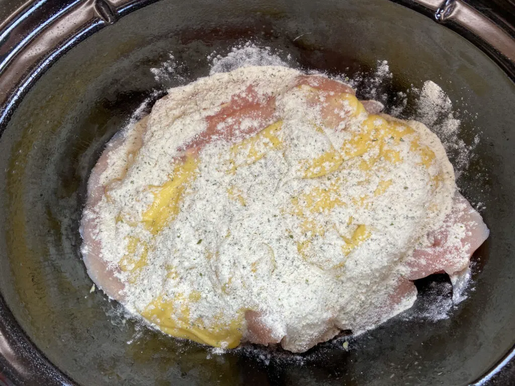 Dry ranch seasoning over chicken breasts in a Crock Pot.