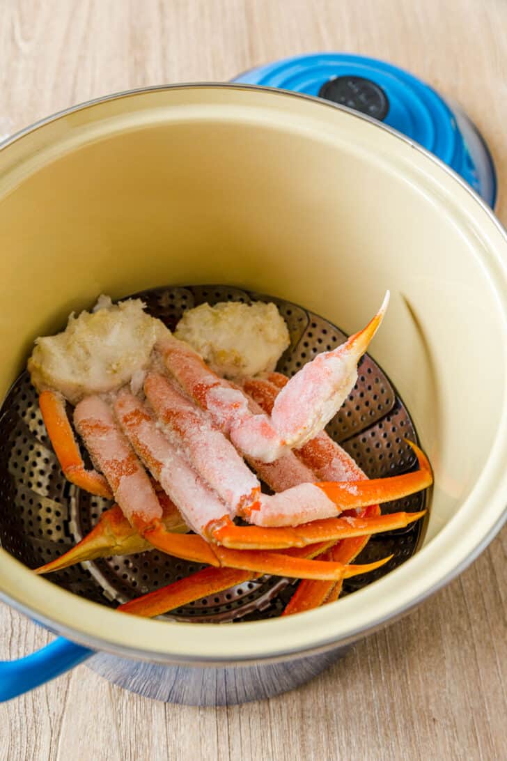 Crab legs in pot with steaming basket