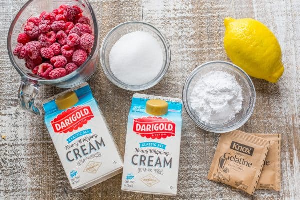 Ingredients for making raspberry mousse with gelatin, raspberries, cream, lemon juice and sugar