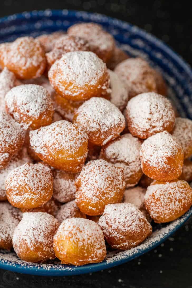 Zeppole in a bowl covered with powdered sugar