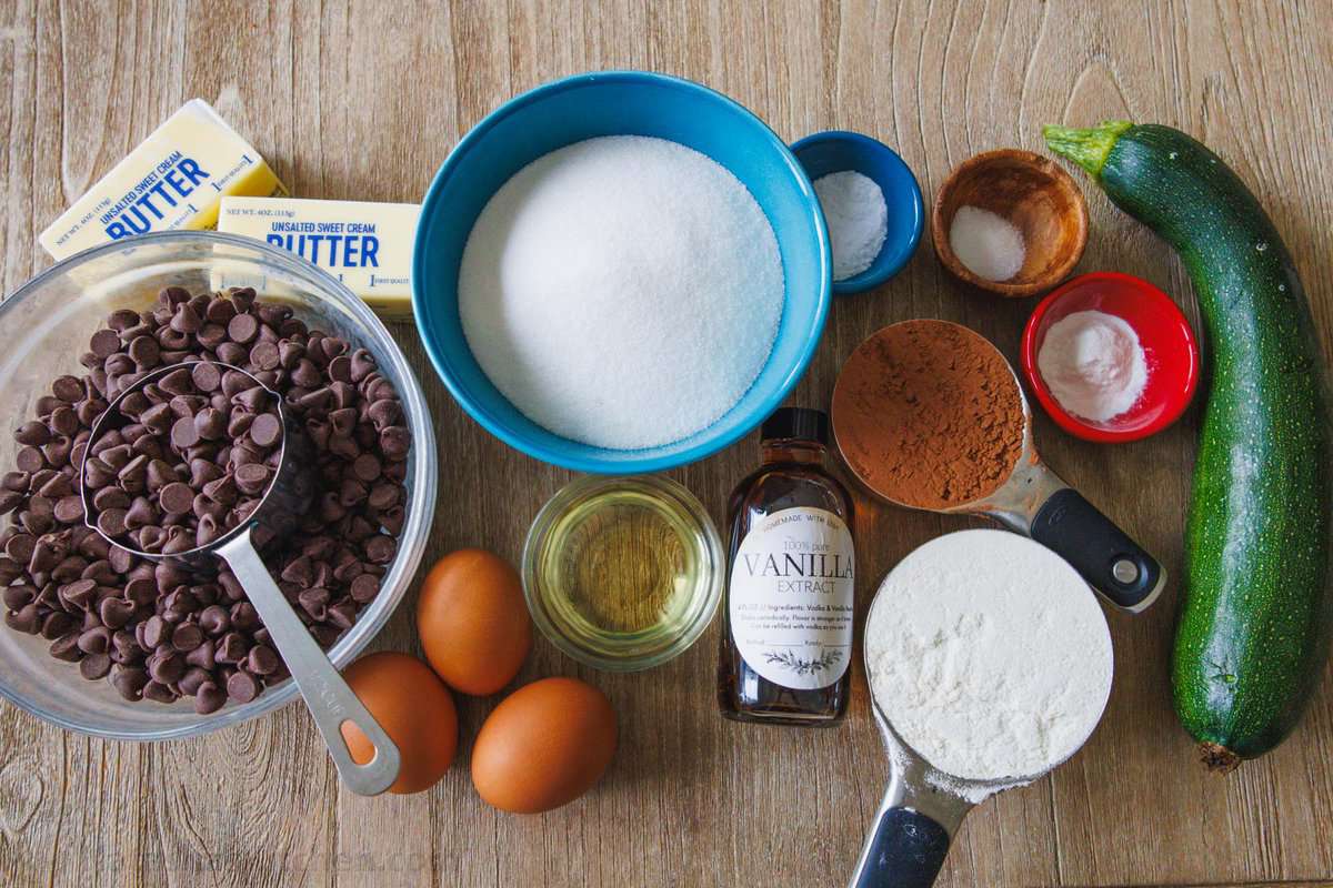 Ingredients for zucchini brownies- butter, eggs, zucchini, chocolate chips, eggs, cocoa powder, vanilla...