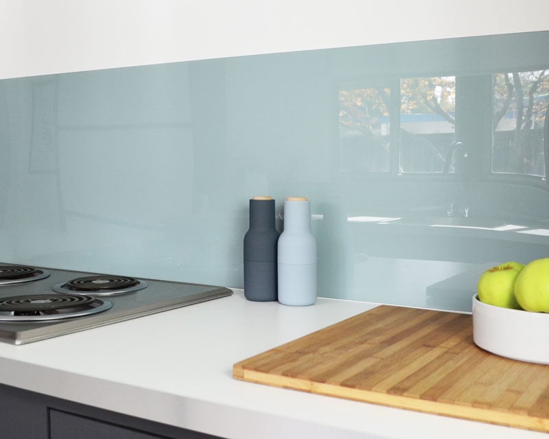 dusty blue shiny backsplash over white kitchen counter