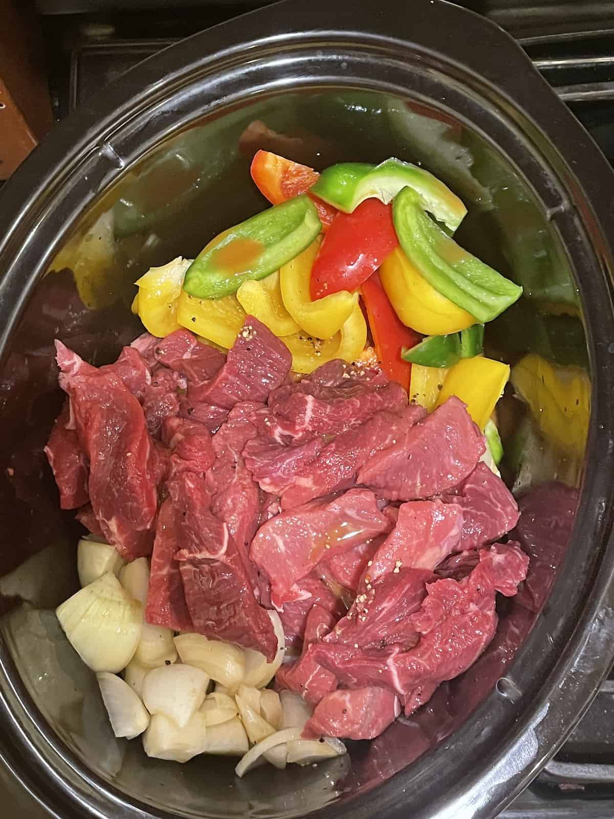 beef, peppers,onions and garlic in a crockpot