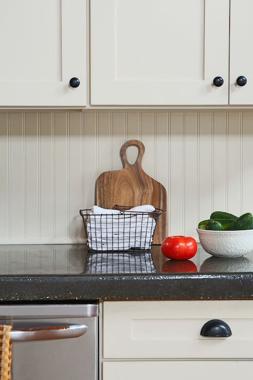 black kitchen counter with white beadboard backsplash 