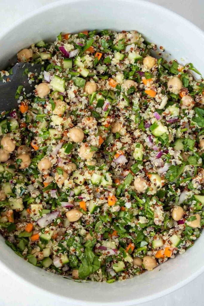 Chickpea and quinoa salad in a large mixing bowl with a spatula.