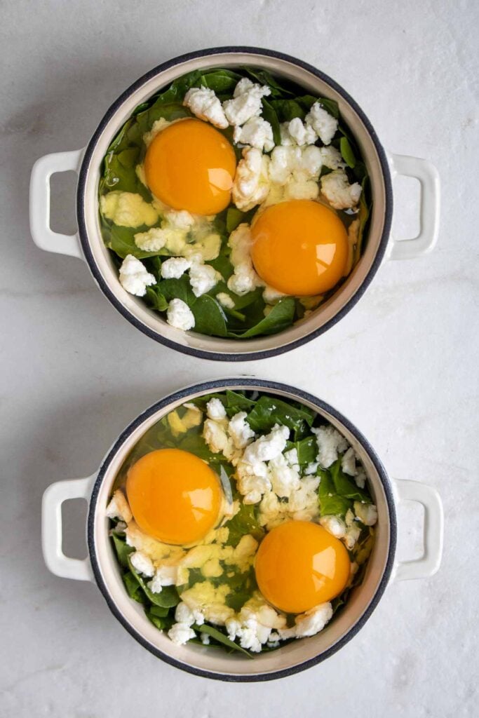 Ramekins filled with spinach, goat cheese, and eggs.