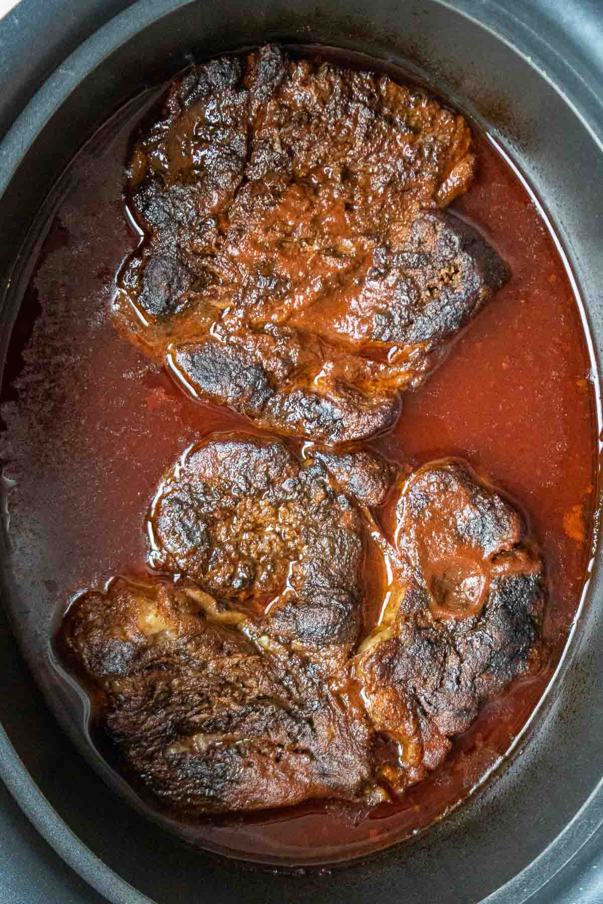 Cooked beef chuck roast in a slow cooker.