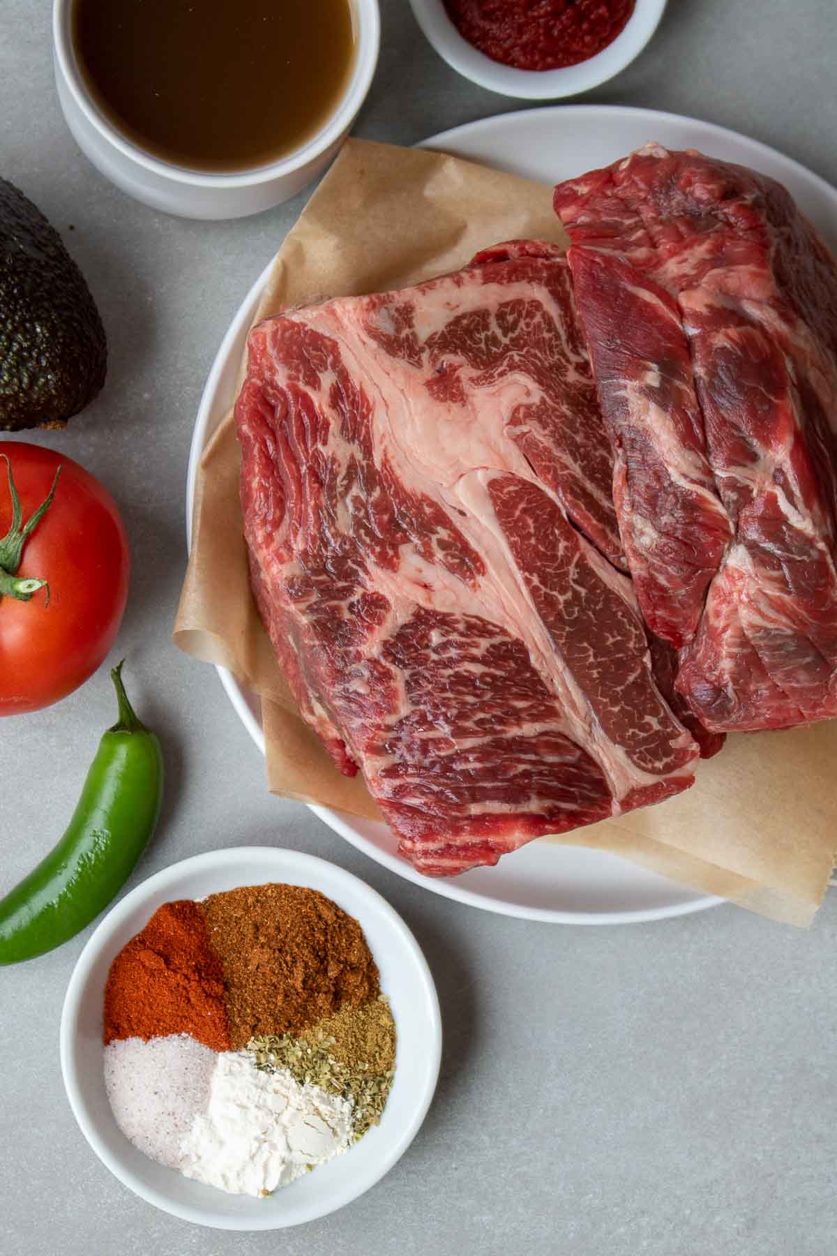 Ingredients to make Mexican shredded beef tacos: beef chuck roast, beef broth, spices, and tomato paste.