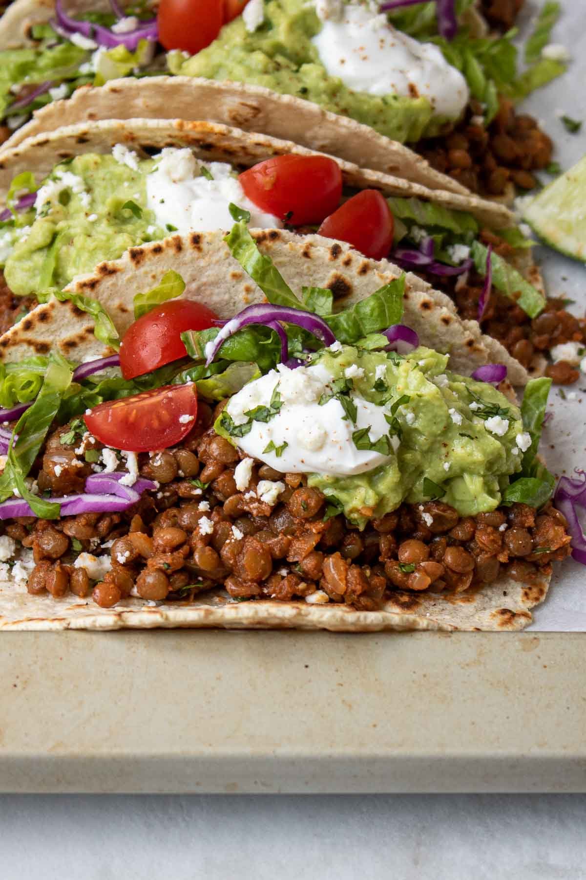 Close up of lentil taco meat in a tortilla with toppings.