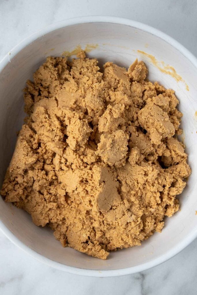 Mixed batter for homemade peanut butter protein bars in a white bowl