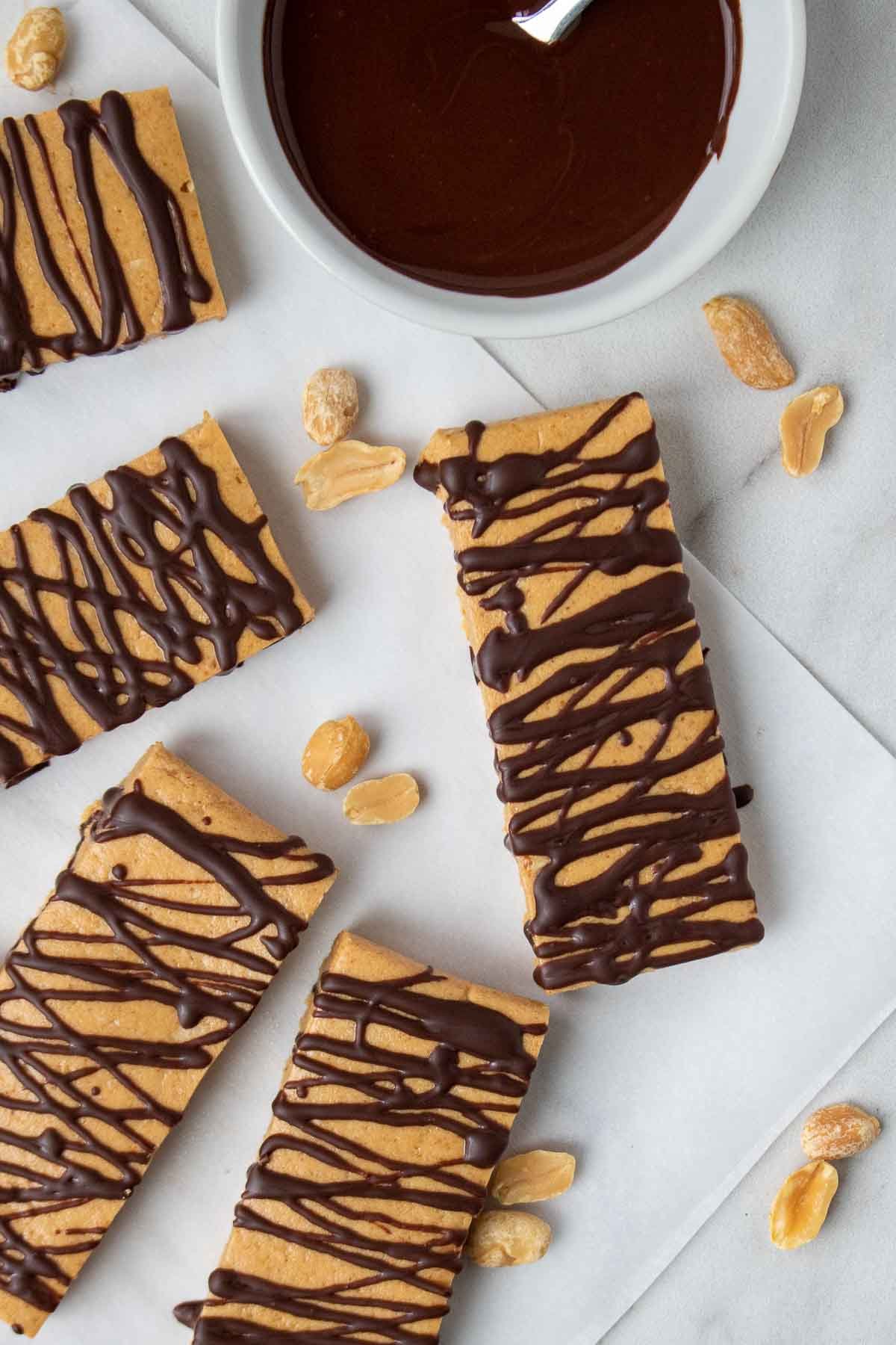 Slide peanut butter protein bars with melted dark chocolate and peanuts