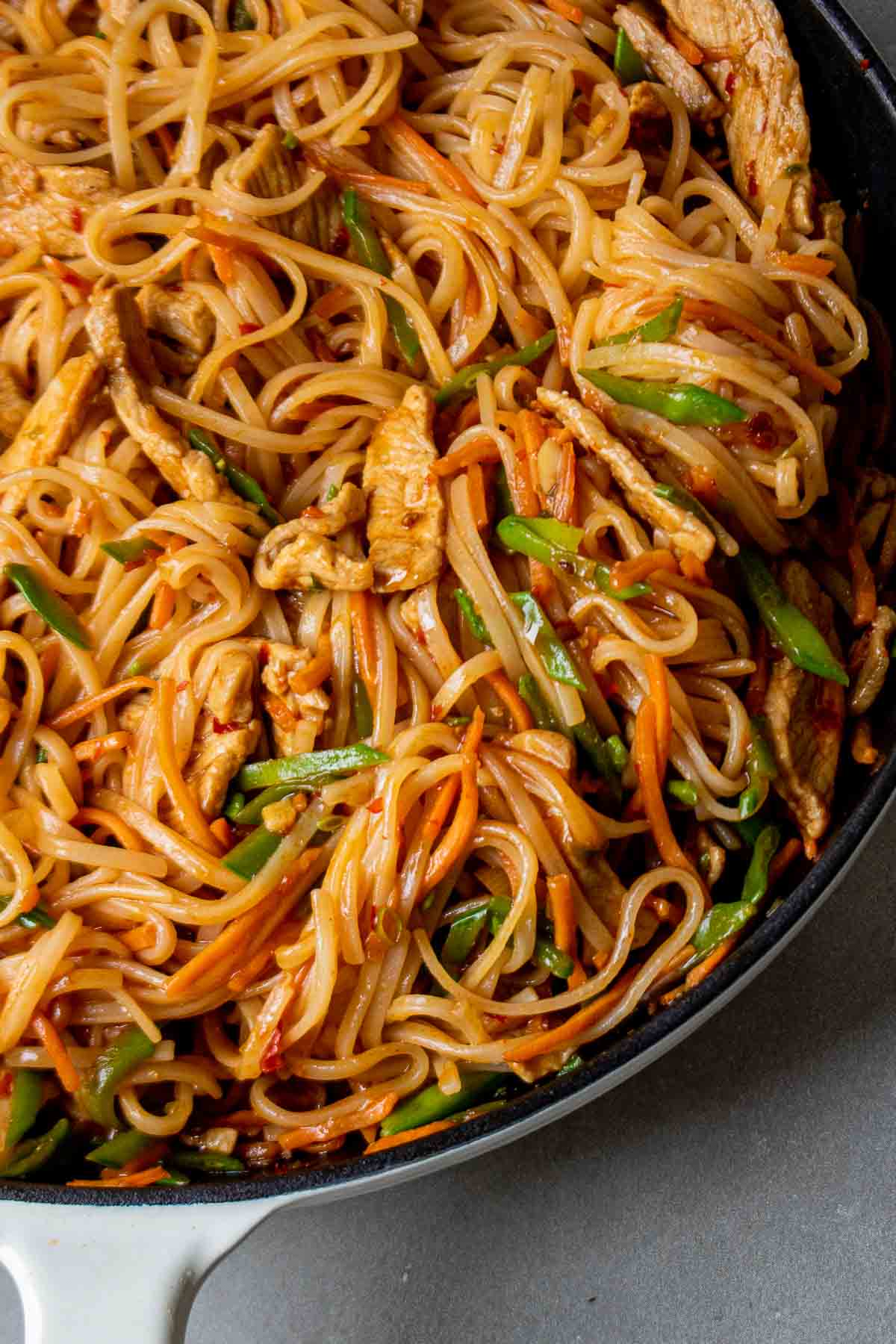 Spicy pork noodles in a large pan.