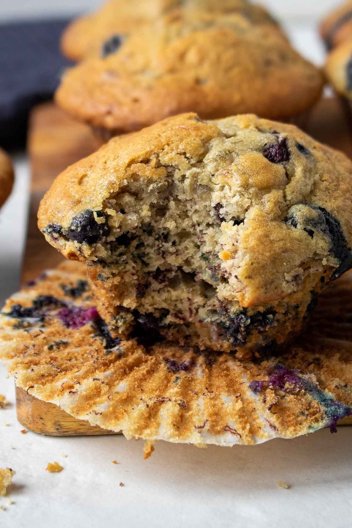 Muffin à la banane et aux myrtilles sur une planche à découper avec une bouchée mangée