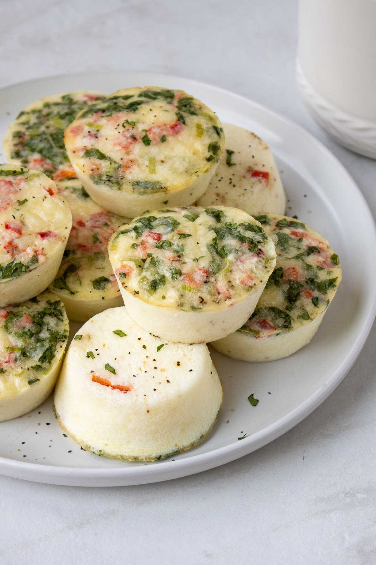 Bouchées de blanc d'œuf au poivron rouge rôti empilées sur une assiette.