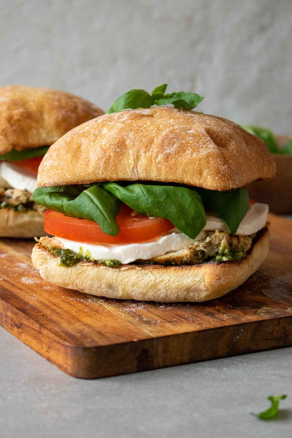Caprese sandwich with grilled chicken on Italian bread on a cutting board