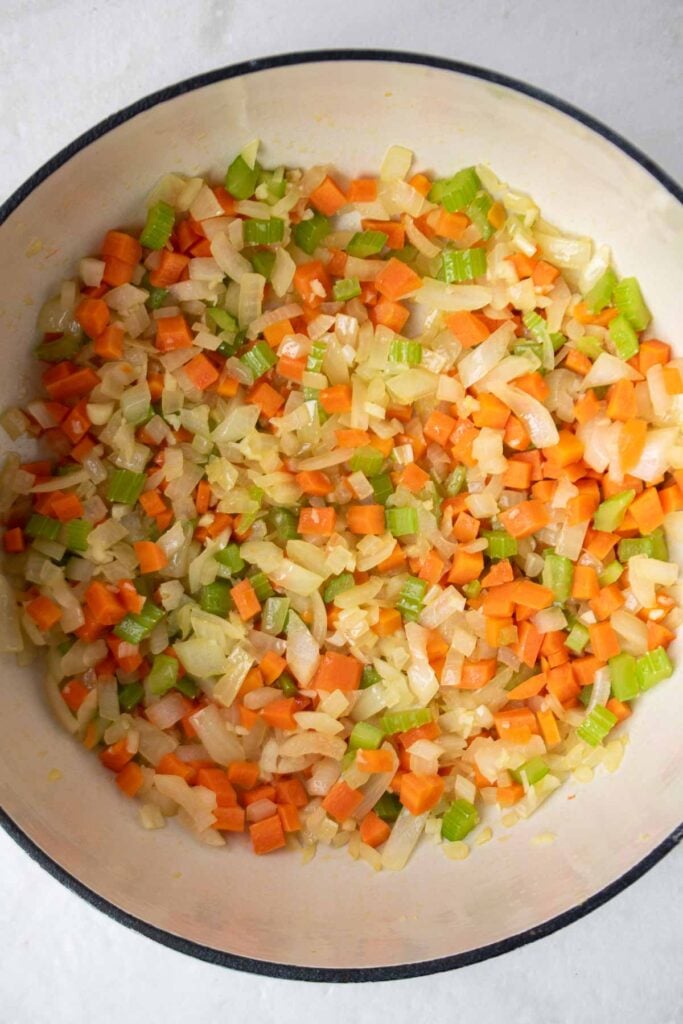 Oignon, carotte et céleri sautés dans une casserole