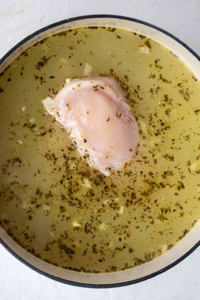 Broth with chicken breasts in a pot