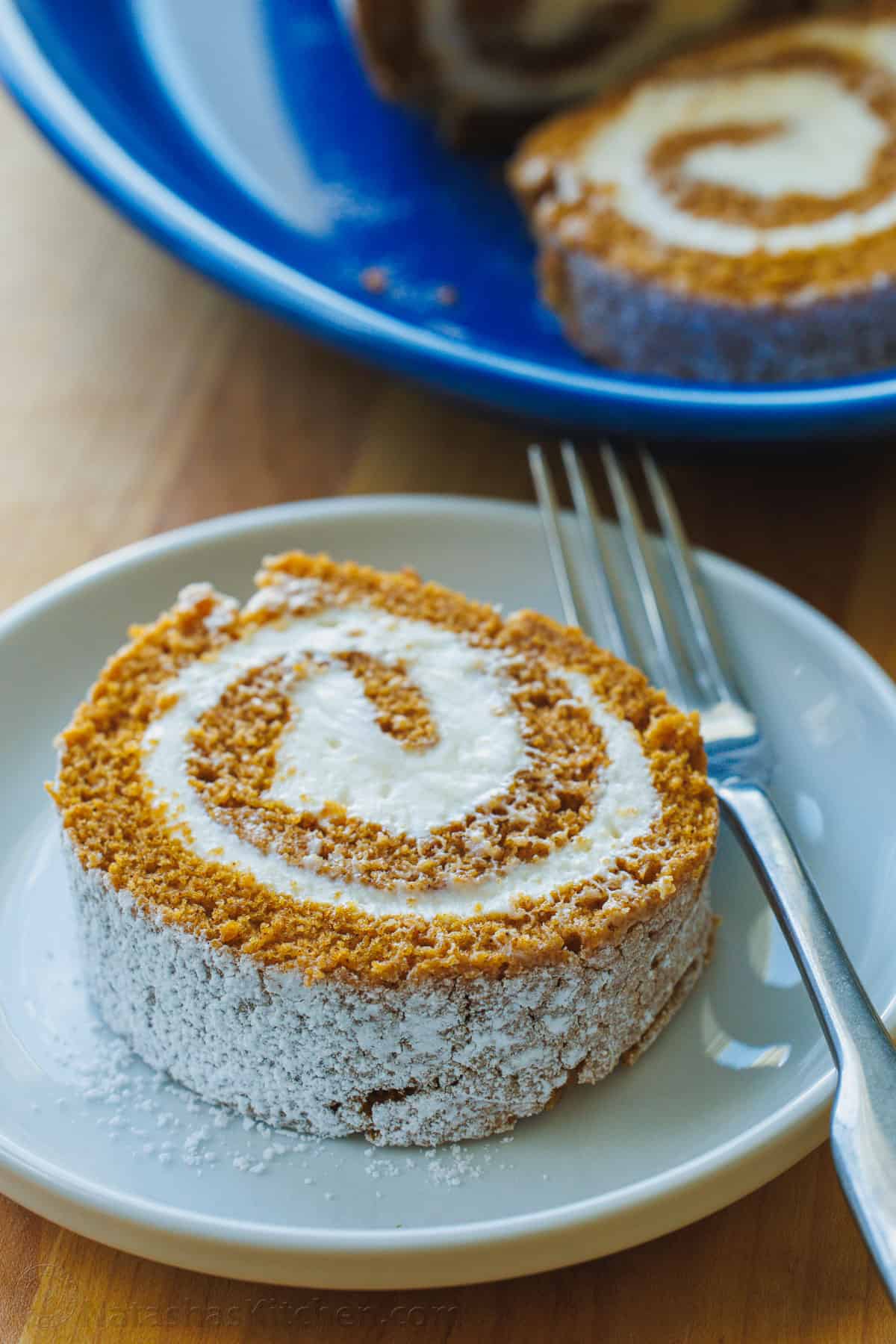 Pumpkin roll slice dusted with powdered sugar on a plate
