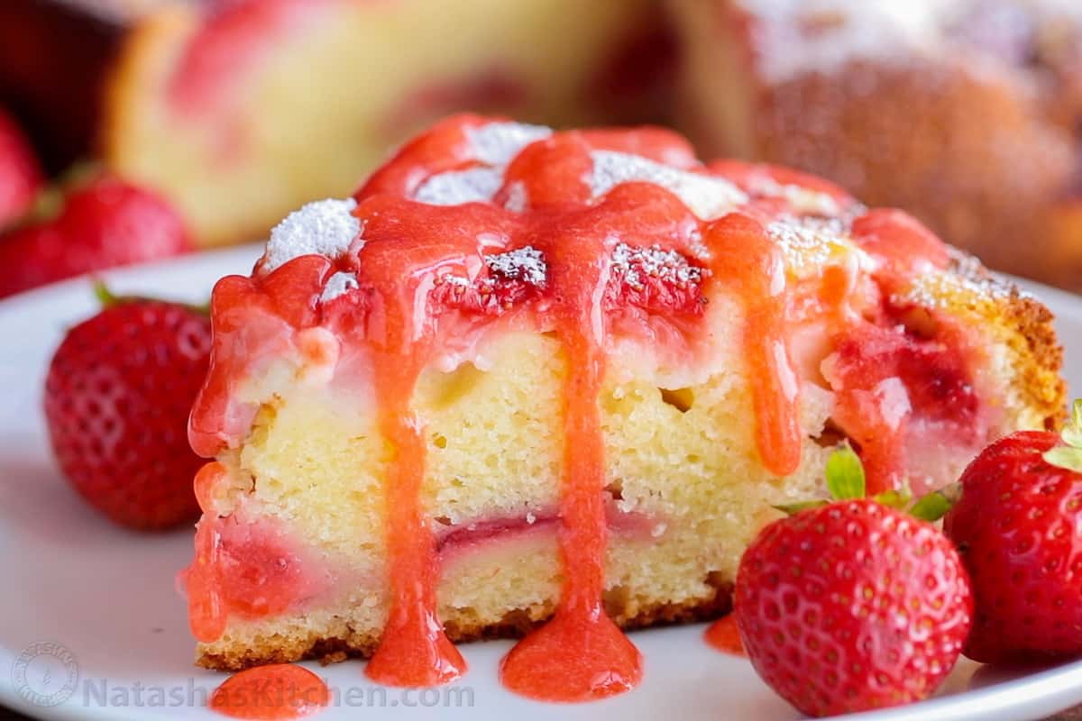 Slice of easy strawberry cake drizzled with strawberry sauce
