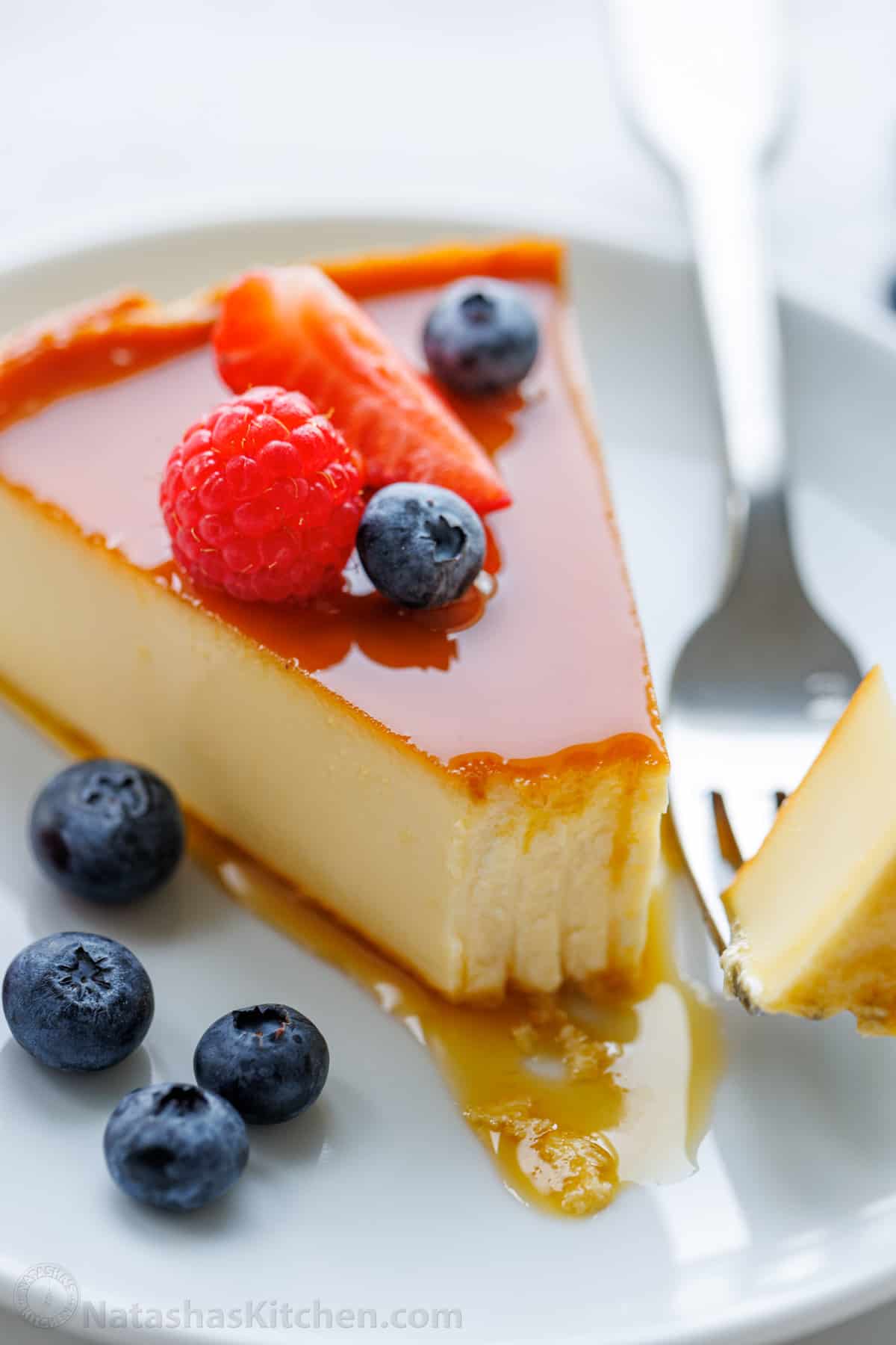 Slice of flan on a plate with a forkful