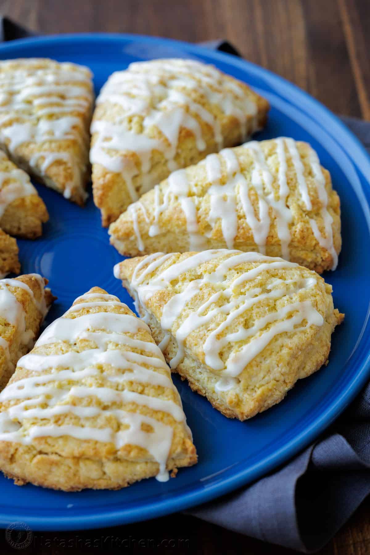 Classic scones arranged on a plate, drizzled with vanilla glaze