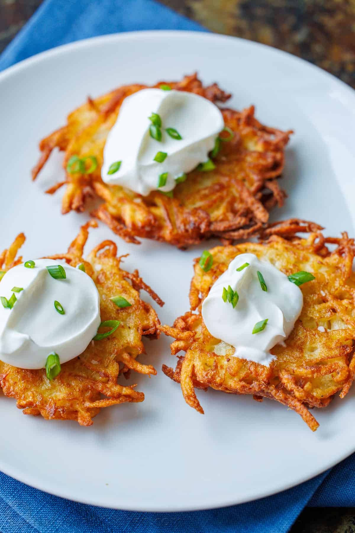 Latkes on plate with sour cream and chives